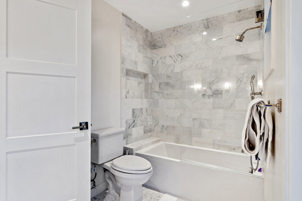Modelo de cuarto de baño actual de tamaño medio con bañera empotrada, combinación de ducha y bañera, baldosas y/o azulejos grises, baldosas y/o azulejos de mármol, paredes grises, aseo y ducha y lavabo bajoencimera