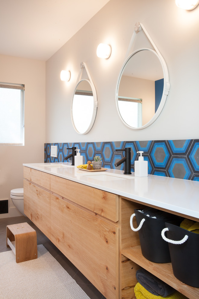 Exempel på ett stort modernt vit vitt en-suite badrum, med släta luckor, skåp i ljust trä, en toalettstol med hel cisternkåpa, blå kakel, vita väggar, ett undermonterad handfat, bänkskiva i kvarts och brunt golv