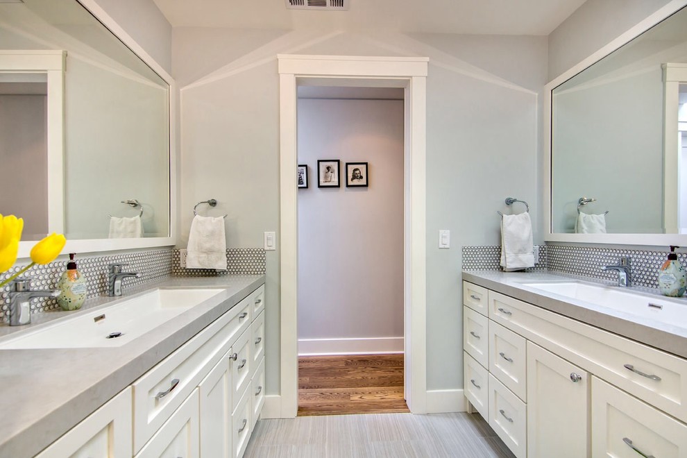 На фото: серо-белая ванная комната в стиле неоклассика (современная классика) с раковиной с несколькими смесителями, фасадами в стиле шейкер, белыми фасадами и белой плиткой