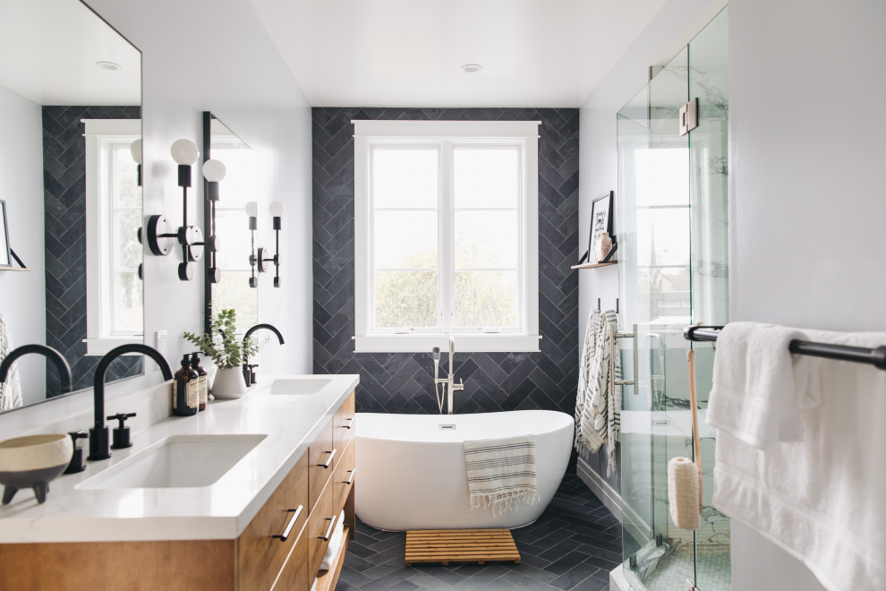Photo of a medium sized traditional ensuite bathroom in San Francisco with flat-panel cabinets, medium wood cabinets, a freestanding bath, an alcove shower, a two-piece toilet, black tiles, slate tiles, grey walls, slate flooring, a submerged sink, engineered stone worktops, black floors, a hinged door, white worktops, an enclosed toilet, double sinks and a floating vanity unit.