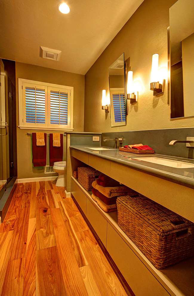Foto de cuarto de baño clásico renovado de tamaño medio con lavabo bajoencimera, armarios abiertos, puertas de armario blancas, encimera de acrílico, paredes beige y suelo de madera en tonos medios