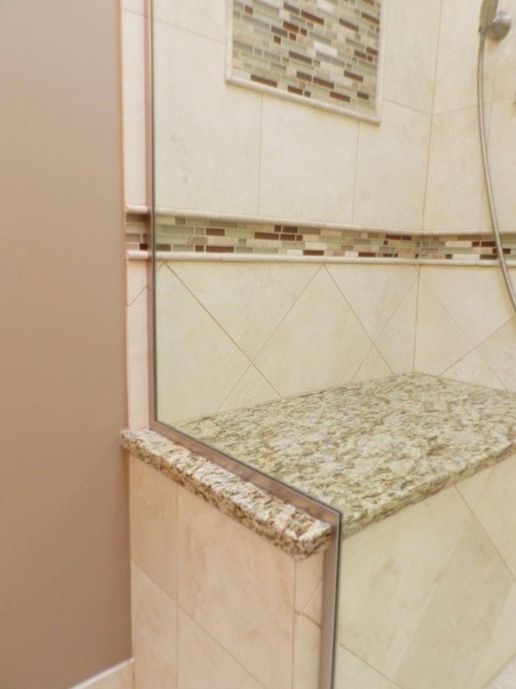 Corner shower - mid-sized traditional master beige tile and stone tile travertine floor corner shower idea in Chicago with an undermount sink, shaker cabinets, light wood cabinets, granite countertops, a two-piece toilet and beige walls