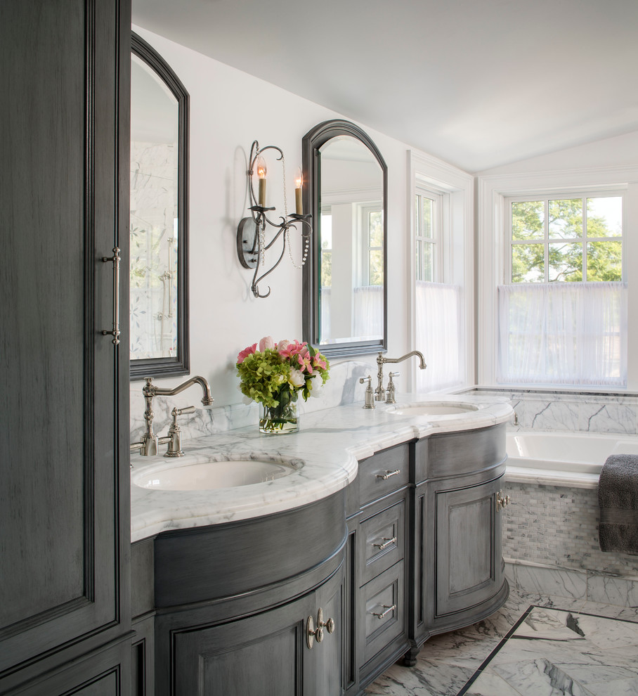Large elegant master gray tile and stone tile limestone floor bathroom photo in Los Angeles with recessed-panel cabinets, gray cabinets, white walls, an undermount sink and marble countertops
