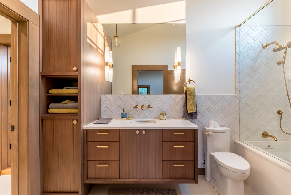 Aménagement d'une salle de bain contemporaine en bois brun avec un placard à porte plane, un combiné douche/baignoire, un carrelage blanc, un mur blanc, un lavabo encastré, un sol beige et une cabine de douche à porte coulissante.