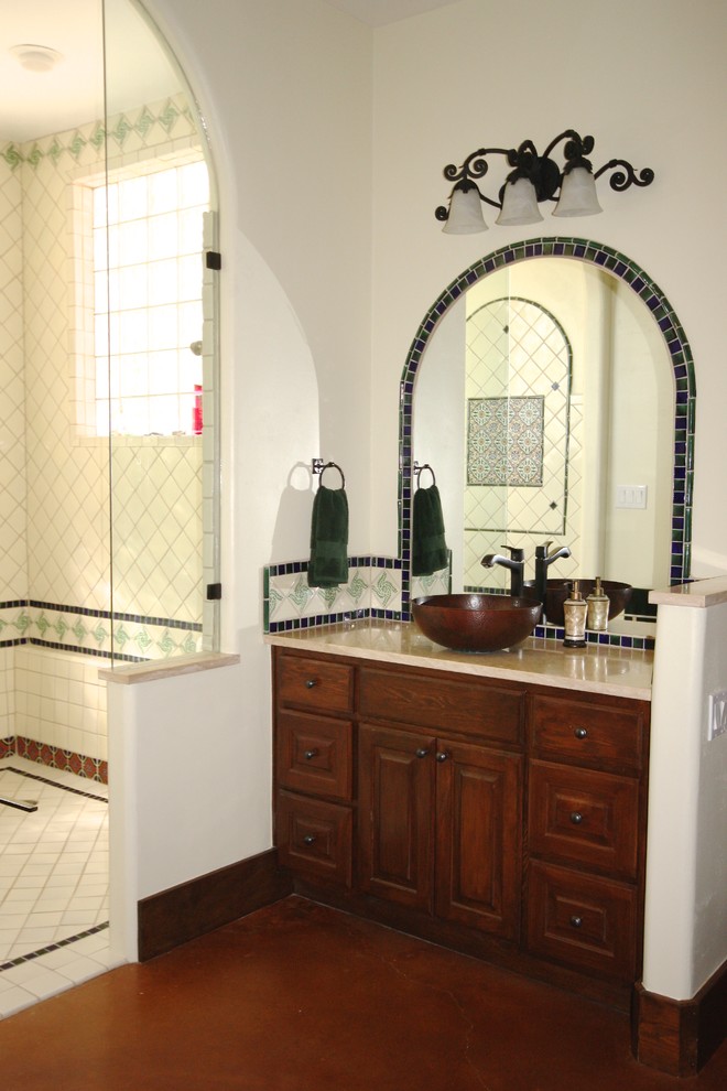 Inspiration for a large southwestern master blue tile and ceramic tile concrete floor drop-in bathtub remodel in Austin with raised-panel cabinets, dark wood cabinets, beige walls and a vessel sink