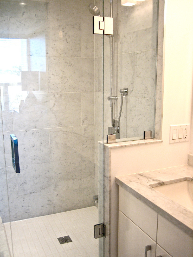 Foto på ett litet funkis en-suite badrum, med ett undermonterad handfat, släta luckor, vita skåp, marmorbänkskiva, en dusch i en alkov, grå kakel, stenkakel, grå väggar och marmorgolv