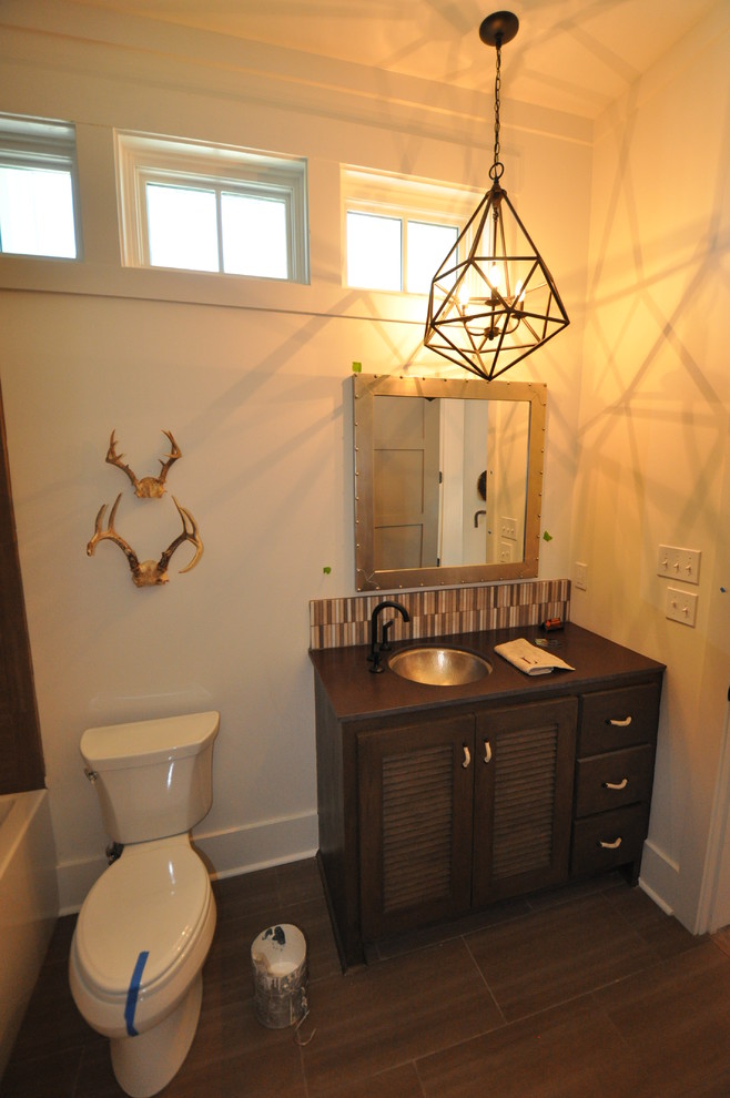 Esempio di una stanza da bagno stile rurale di medie dimensioni con ante a persiana, ante in legno bruno, vasca ad alcova, vasca/doccia e lavabo sottopiano