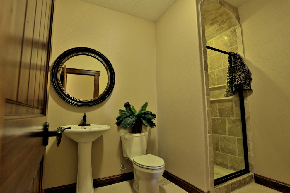 Kleines Mediterranes Badezimmer mit Sockelwaschbecken, Duschnische, Wandtoilette mit Spülkasten, braunen Fliesen, Steinfliesen, beiger Wandfarbe und Travertin in Dallas