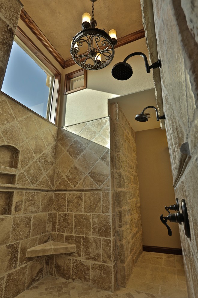 Photo of a large mediterranean bathroom in Dallas with a submerged sink, shaker cabinets, dark wood cabinets, granite worktops, a built-in bath, a walk-in shower, a two-piece toilet, beige tiles, stone tiles, beige walls and travertine flooring.