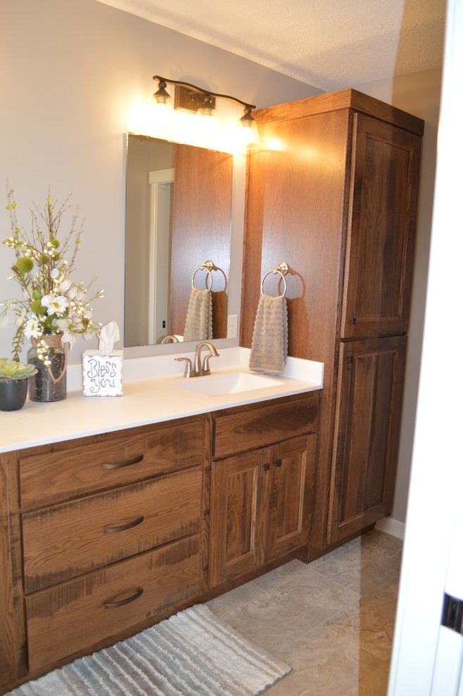 Photo of a medium sized traditional ensuite bathroom in Grand Rapids with recessed-panel cabinets, distressed cabinets, a corner shower, a one-piece toilet, beige tiles, ceramic tiles, beige walls, lino flooring, an integrated sink, engineered stone worktops, beige floors and an open shower.
