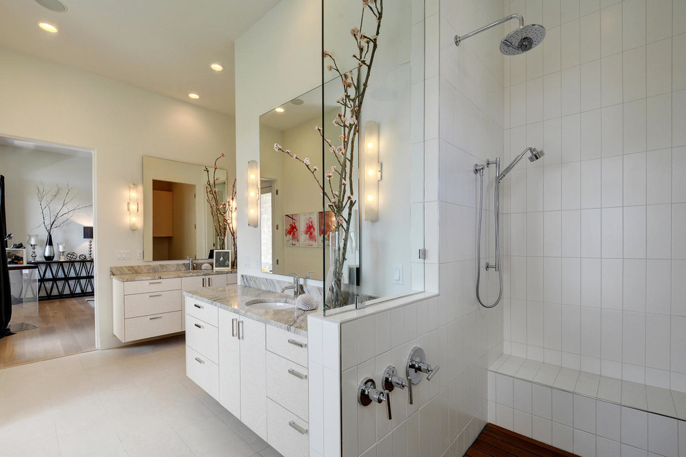 Свежая идея для дизайна: большая главная ванная комната в стиле модернизм с плоскими фасадами, белыми фасадами, душем в нише, белой плиткой, бежевыми стенами, врезной раковиной и мраморной столешницей - отличное фото интерьера