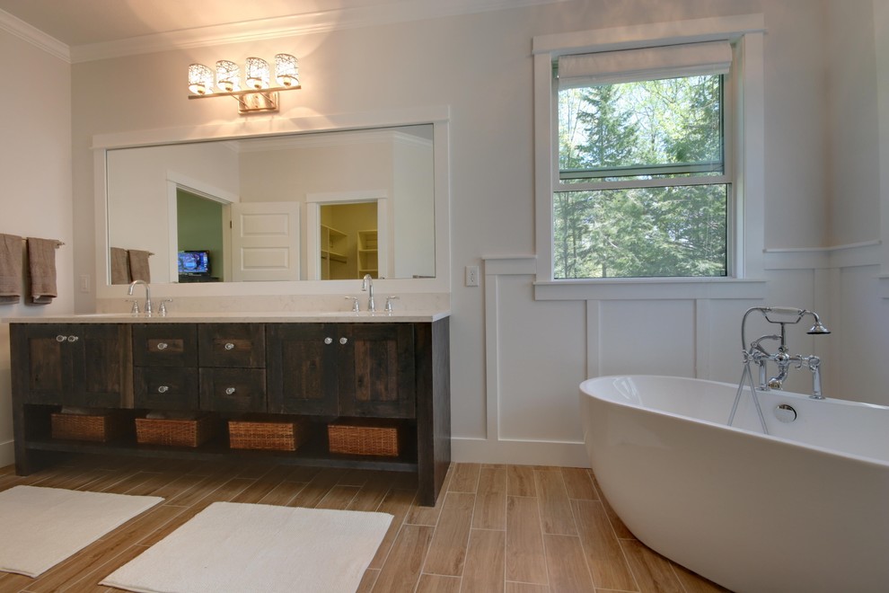 Aménagement d'une grande salle de bain principale craftsman en bois vieilli avec un placard en trompe-l'oeil, un plan de toilette en quartz, une baignoire indépendante, un carrelage beige, un carrelage imitation parquet et un mur blanc.