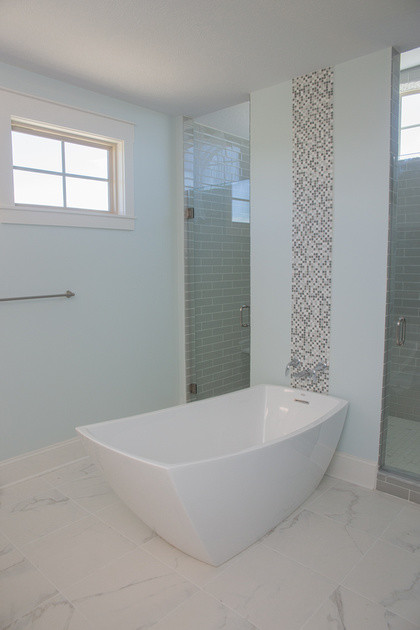 Идея дизайна: большая главная ванная комната в стиле неоклассика (современная классика) с фасадами в стиле шейкер, серыми фасадами, отдельно стоящей ванной, двойным душем, раздельным унитазом, белой плиткой, стеклянной плиткой, синими стенами, мраморным полом, врезной раковиной и столешницей из гранита