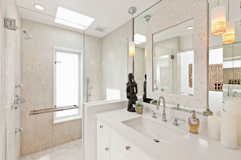 Diseño de cuarto de baño actual con lavabo bajoencimera, armarios con paneles lisos, puertas de armario blancas, ducha empotrada y baldosas y/o azulejos beige