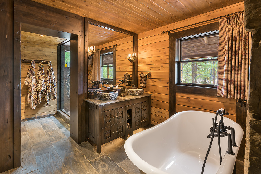 Exempel på ett mellanstort rustikt en-suite badrum, med ett badkar med tassar, en dusch i en alkov, skifferkakel, skiffergolv, ett fristående handfat, bänkskiva i kalksten, skåp i mörkt trä, bruna väggar, grått golv och luckor med infälld panel