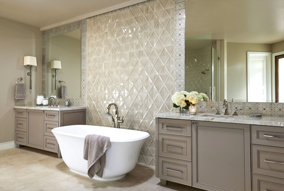 Foto di una stanza da bagno tradizionale con ante in stile shaker, ante grigie, vasca freestanding, piastrelle grigie, piastrelle di vetro, pareti grigie, lavabo sottopiano, pavimento beige e top grigio