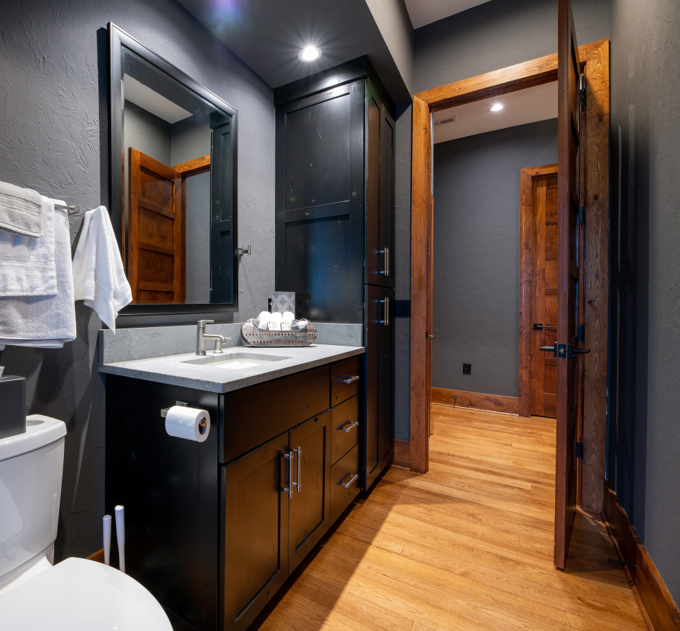 На фото: ванная комната среднего размера в стиле рустика с фасадами в стиле шейкер, черными фасадами, раздельным унитазом, серыми стенами, паркетным полом среднего тона, врезной раковиной, столешницей из бетона, коричневым полом и серой столешницей
