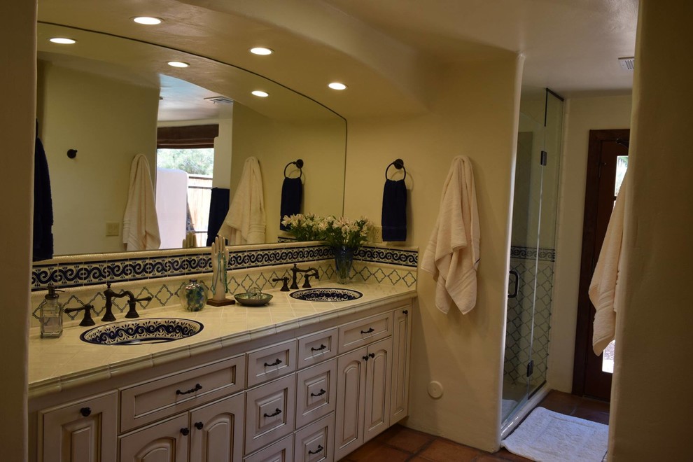 Idéer för mellanstora amerikanska en-suite badrum, med luckor med upphöjd panel, vita skåp, ett badkar med tassar, en dusch i en alkov, blå kakel, vit kakel, vita väggar, ett nedsänkt handfat och dusch med gångjärnsdörr