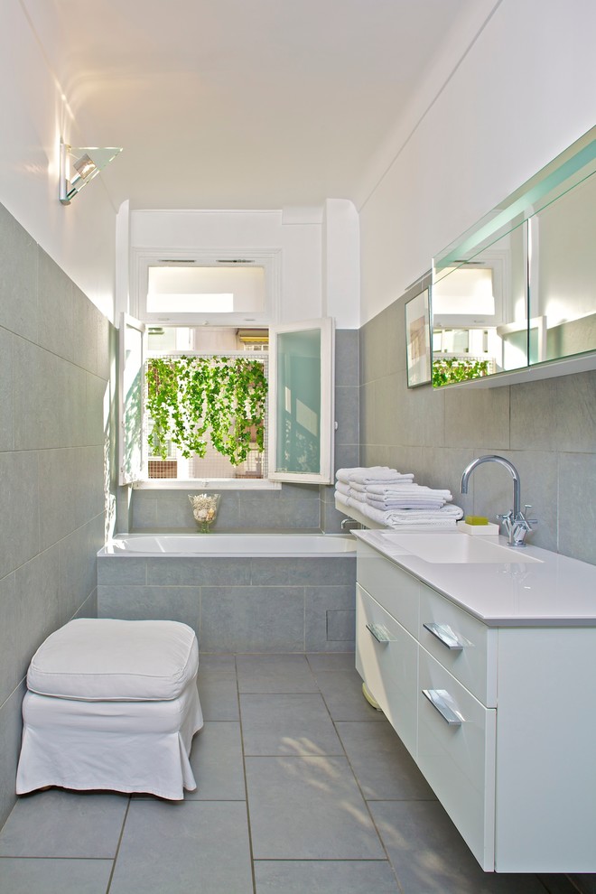 Imagen de cuarto de baño principal contemporáneo pequeño con bañera empotrada, baldosas y/o azulejos grises, paredes grises y lavabo integrado