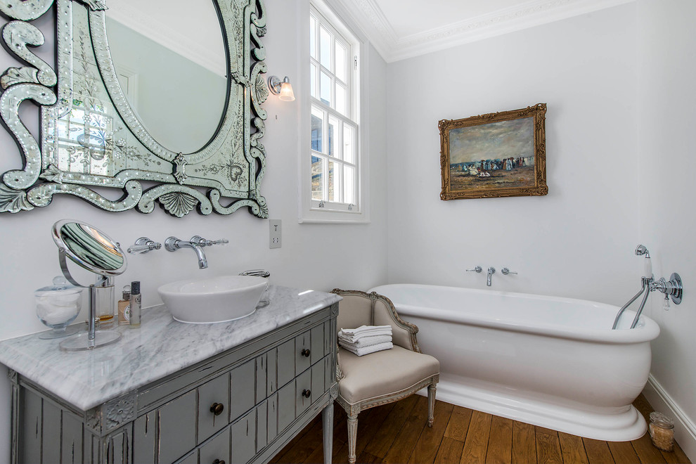 Idéer för att renovera ett vintage badrum, med släta luckor, ett fristående badkar, grå väggar, mellanmörkt trägolv och ett fristående handfat
