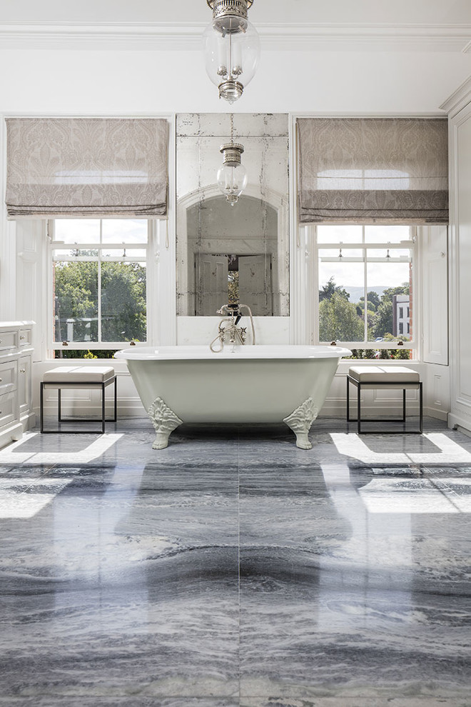 Klassisk inredning av ett badrum, med ett fristående badkar, marmorgolv och grått golv