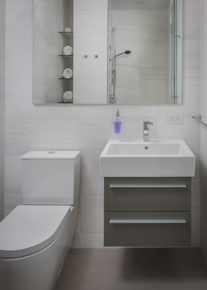 Стильный дизайн: ванная комната среднего размера в стиле модернизм с плоскими фасадами, серыми фасадами, душем в нише, унитазом-моноблоком, белой плиткой, керамической плиткой, белыми стенами, полом из керамической плитки, раковиной с пьедесталом, столешницей из кварцита, бежевым полом, душем с раздвижными дверями, белой столешницей и душевой кабиной - последний тренд