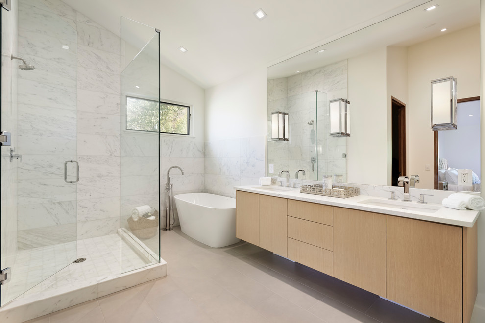 Источник вдохновения для домашнего уюта: ванная комната в современном стиле с плоскими фасадами, светлыми деревянными фасадами, отдельно стоящей ванной, угловым душем, белой плиткой, белыми стенами, врезной раковиной, серым полом, душем с распашными дверями, белой столешницей и зеркалом с подсветкой