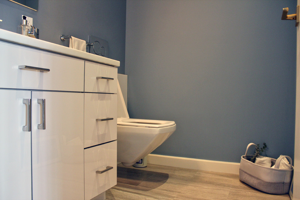 Immagine di una piccola stanza da bagno con doccia moderna con ante lisce, ante bianche, piastrelle blu, pareti grigie e lavabo sottopiano
