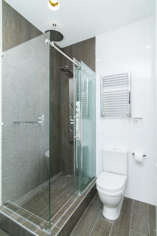 Idées déco pour une salle de bain principale contemporaine en bois foncé de taille moyenne avec une baignoire indépendante, une douche d'angle, WC à poser, un carrelage blanc, un mur blanc, un lavabo intégré, un sol marron et une cabine de douche à porte coulissante.