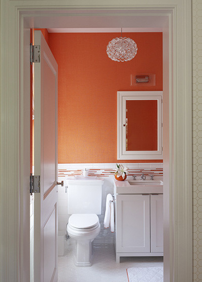 Idée de décoration pour une salle de bain tradition pour enfant avec un placard avec porte à panneau encastré, des portes de placard blanches, WC suspendus, un carrelage blanc, mosaïque, un mur orange et un sol en carrelage de terre cuite.