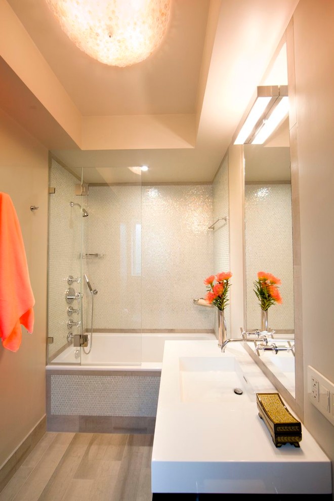 Cette photo montre une salle de bain tendance avec un lavabo intégré, une baignoire en alcôve, un combiné douche/baignoire, un carrelage blanc et mosaïque.