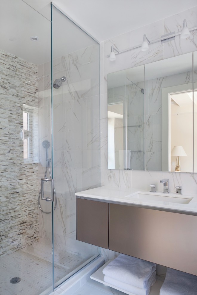 Design ideas for a small contemporary ensuite bathroom in New York with white walls, flat-panel cabinets, an alcove shower, a one-piece toilet, stone tiles, porcelain flooring, a built-in sink and marble worktops.