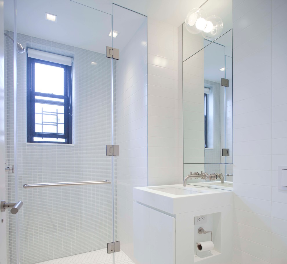 Exemple d'une douche en alcôve tendance avec un placard à porte plane, des portes de placard blanches, un carrelage gris et un mur blanc.