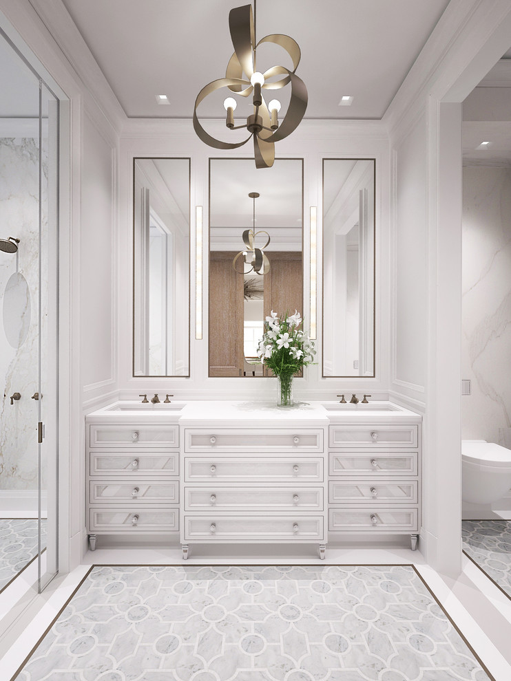 Inredning av ett klassiskt stort en-suite badrum, med luckor med infälld panel, vita skåp, ett fristående badkar, en dusch/badkar-kombination, en vägghängd toalettstol, vit kakel, stenhäll, vita väggar, mosaikgolv, ett undermonterad handfat och marmorbänkskiva