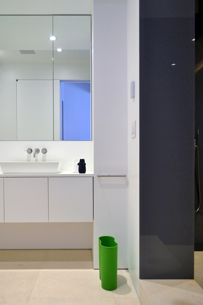 Diseño de cuarto de baño actual con lavabo sobreencimera, armarios con paneles lisos y puertas de armario blancas