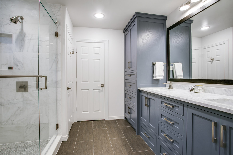 This is an example of a medium sized classic ensuite bathroom in Dallas with shaker cabinets, blue cabinets, stone tiles, white walls, porcelain flooring, a submerged sink, marble worktops and a corner shower.