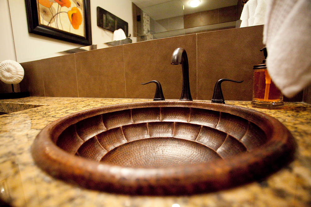 Foto på ett mellanstort rustikt badrum med dusch, med skåp i shakerstil, orange skåp, ett platsbyggt badkar, en dusch/badkar-kombination, en toalettstol med hel cisternkåpa, brun kakel, keramikplattor, beige väggar, klinkergolv i porslin, ett nedsänkt handfat och granitbänkskiva