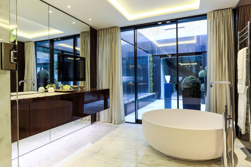 Идея дизайна: главная ванная комната в современном стиле с плоскими фасадами, коричневыми фасадами, отдельно стоящей ванной, белым полом и мраморным полом