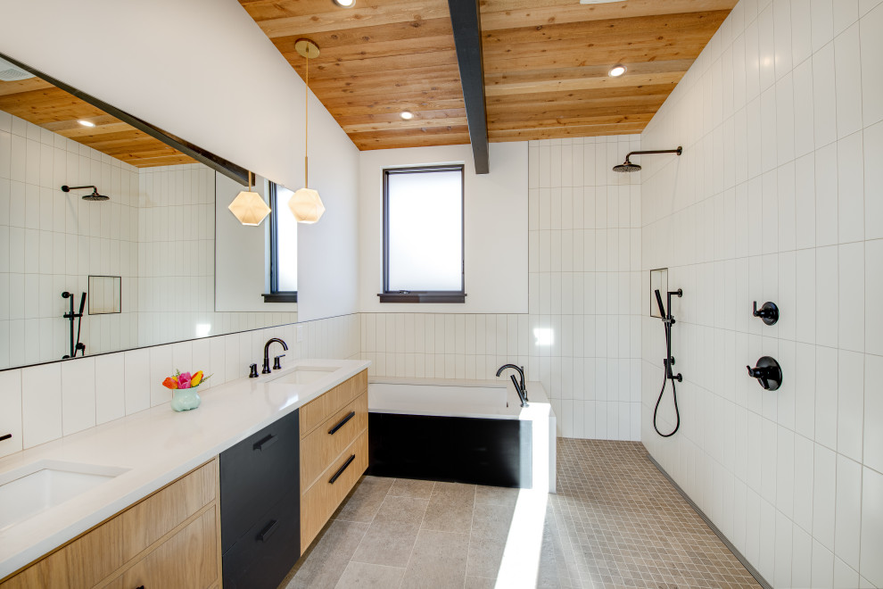 Свежая идея для дизайна: большая главная ванная комната в современном стиле с плоскими фасадами, бежевыми фасадами, полновстраиваемой ванной, открытым душем, белой плиткой, керамогранитной плиткой, белыми стенами, полом из керамогранита, врезной раковиной, серым полом, открытым душем, белой столешницей, нишей, тумбой под две раковины, деревянным потолком и встроенной тумбой - отличное фото интерьера