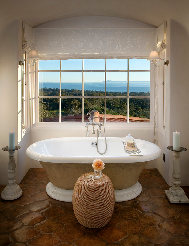 Mediterranes Badezimmer En Suite mit weißen Schränken, freistehender Badewanne und braunen Fliesen in Santa Barbara