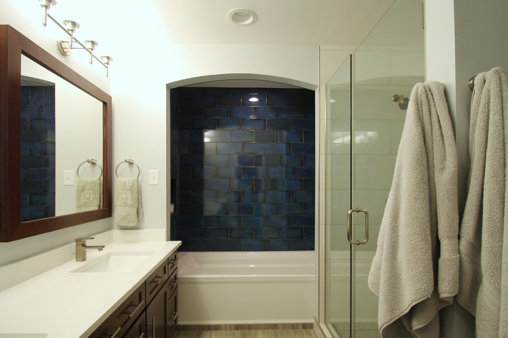 Пример оригинального дизайна: большая главная ванная комната в стиле неоклассика (современная классика) с плоскими фасадами, темными деревянными фасадами, ванной в нише, душем над ванной, раздельным унитазом, белой плиткой, керамогранитной плиткой, синими стенами, полом из керамогранита, врезной раковиной и столешницей из искусственного кварца