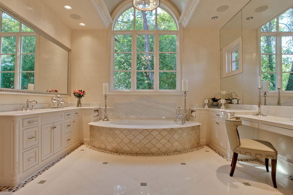 Large tuscan master limestone floor and white floor bathroom photo in Dallas with beaded inset cabinets, white cabinets, an undermount tub, beige walls, an undermount sink, marble countertops and white countertops