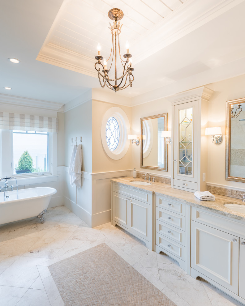 Inspiration för ett stort vintage beige beige en-suite badrum, med luckor med profilerade fronter, vita skåp, ett badkar med tassar, en hörndusch, beige väggar, marmorgolv, ett undermonterad handfat, granitbänkskiva och vitt golv