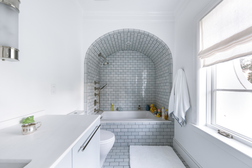 Inspiration for a traditional bathroom in Dallas with flat-panel cabinets, grey cabinets, a submerged bath, a shower/bath combination, grey tiles, metro tiles, white walls, a submerged sink, grey floors, an open shower and white worktops.