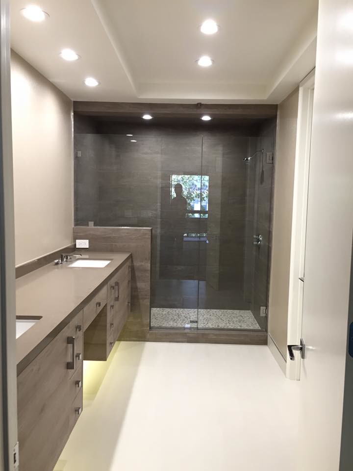 Modernes Badezimmer mit flächenbündigen Schrankfronten, hellen Holzschränken, Duschnische, beigen Fliesen und weißer Wandfarbe in Los Angeles