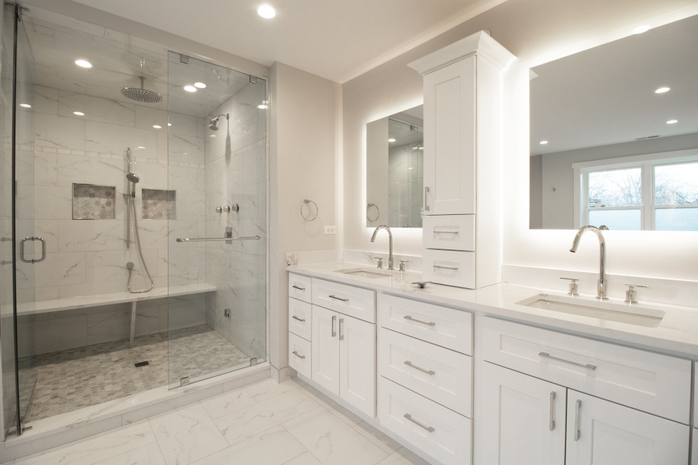 Design ideas for a large contemporary ensuite bathroom in Chicago with shaker cabinets, white cabinets, a freestanding bath, a walk-in shower, grey tiles, porcelain tiles, white walls, ceramic flooring, quartz worktops, beige floors, white worktops, a shower bench, double sinks, a built in vanity unit, a one-piece toilet, a submerged sink and a hinged door.