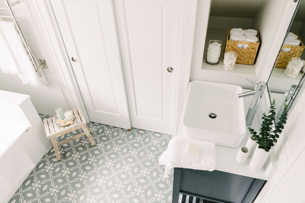 Example of a mid-sized transitional 3/4 white tile and subway tile cement tile floor and blue floor bathroom design in Chicago with furniture-like cabinets, blue cabinets, white walls, a vessel sink, solid surface countertops and white countertops