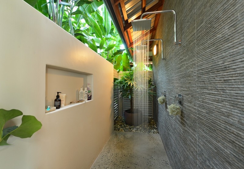 Imagen de cuarto de baño principal asiático grande con ducha abierta, baldosas y/o azulejos grises, baldosas y/o azulejos de piedra, paredes beige y suelo de cemento