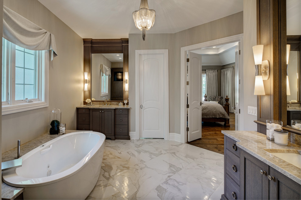 This is an example of a large classic ensuite bathroom in Chicago with recessed-panel cabinets, grey cabinets, a freestanding bath, grey walls, porcelain flooring, a submerged sink, quartz worktops, white floors and white worktops.