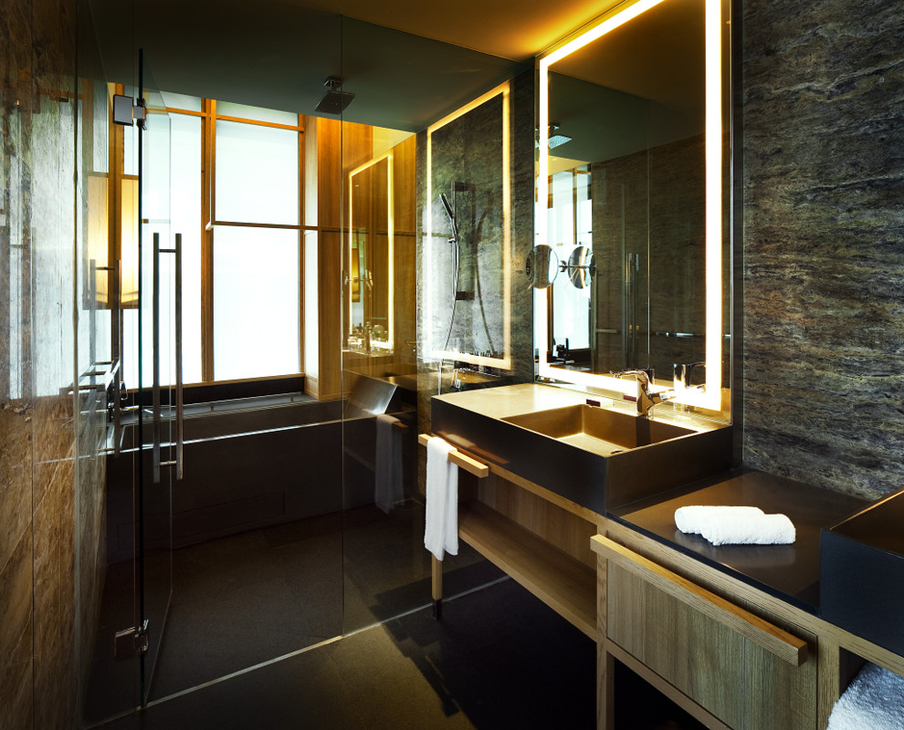 Inspiration för mellanstora moderna en-suite badrum, med ett integrerad handfat, möbel-liknande, skåp i ljust trä, granitbänkskiva, ett badkar i en alkov, en kantlös dusch, flerfärgad kakel, stenkakel, flerfärgade väggar och klinkergolv i keramik